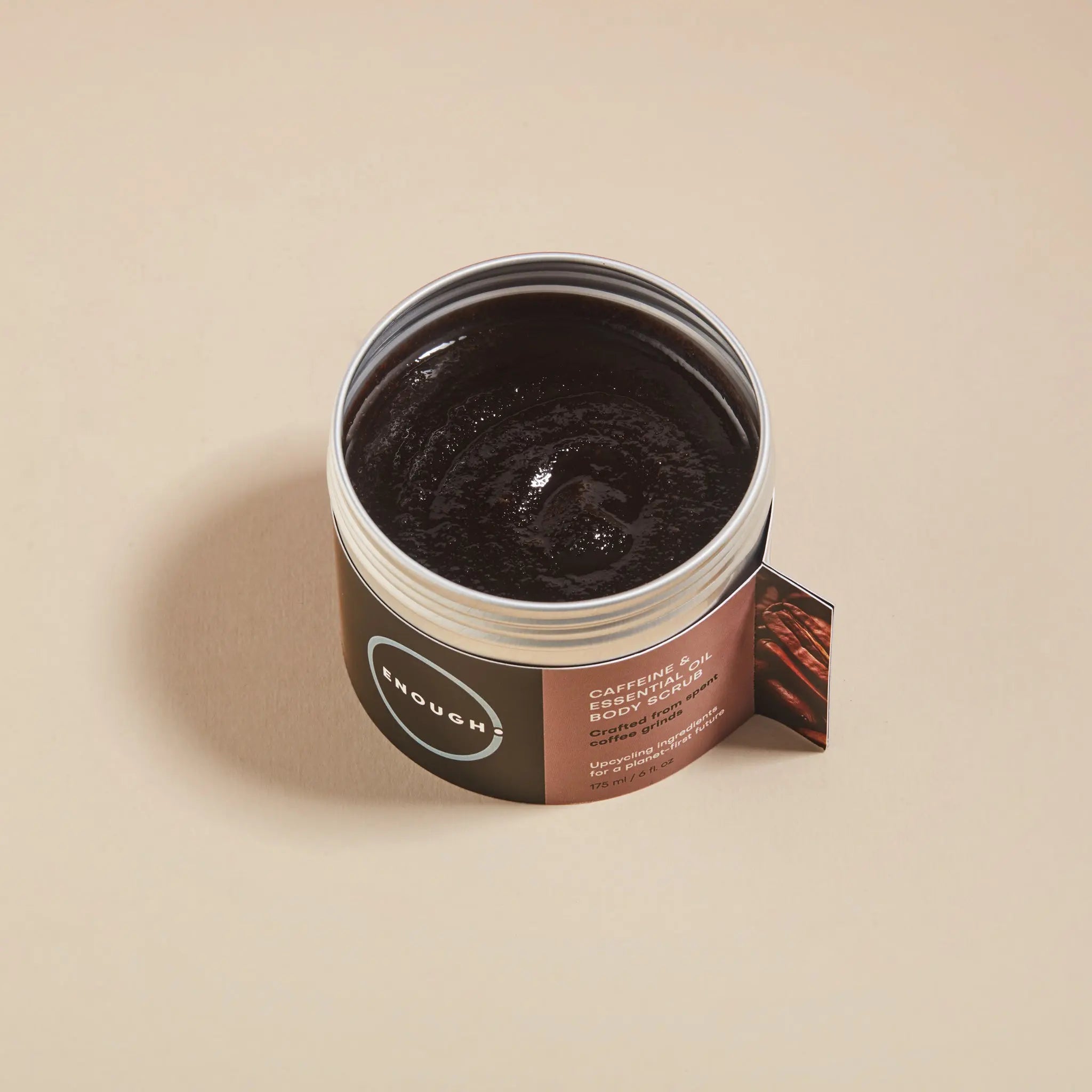 Open jar of ENOUGH caffeine and essential oil body scrub 