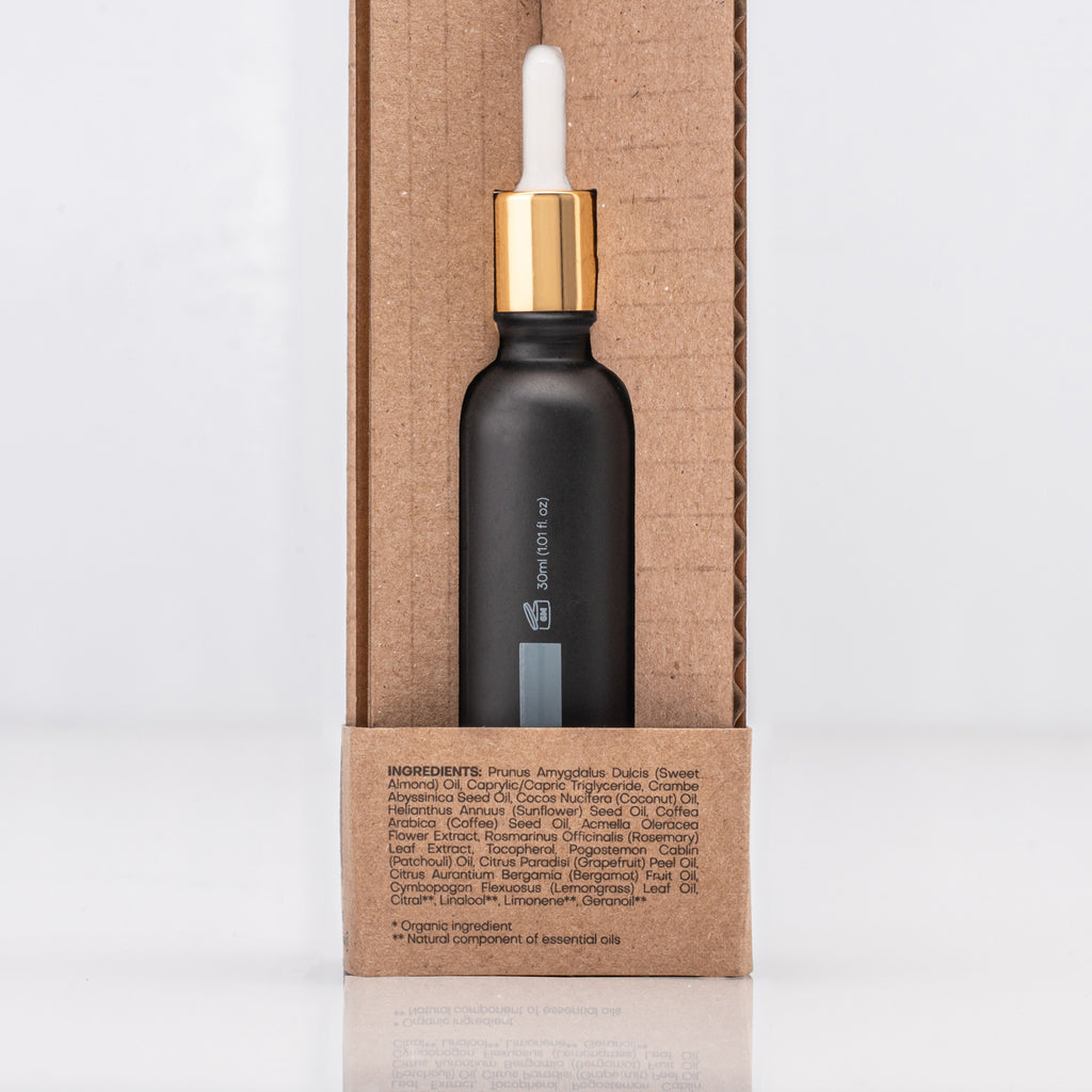 Black dropper bottle with gold cap containing Caffeine Antioxidant serum on a cardboard box with ingredient list in text
