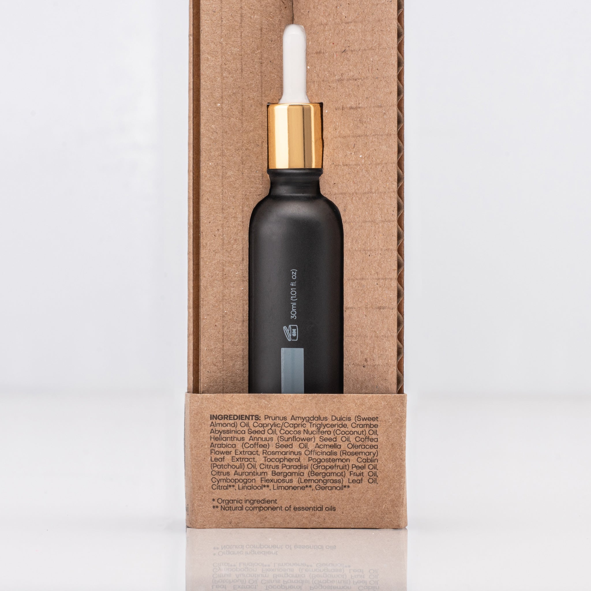 Black dropper bottle with gold cap containing Caffeine Antioxidant serum on a cardboard box with ingredient list in text
