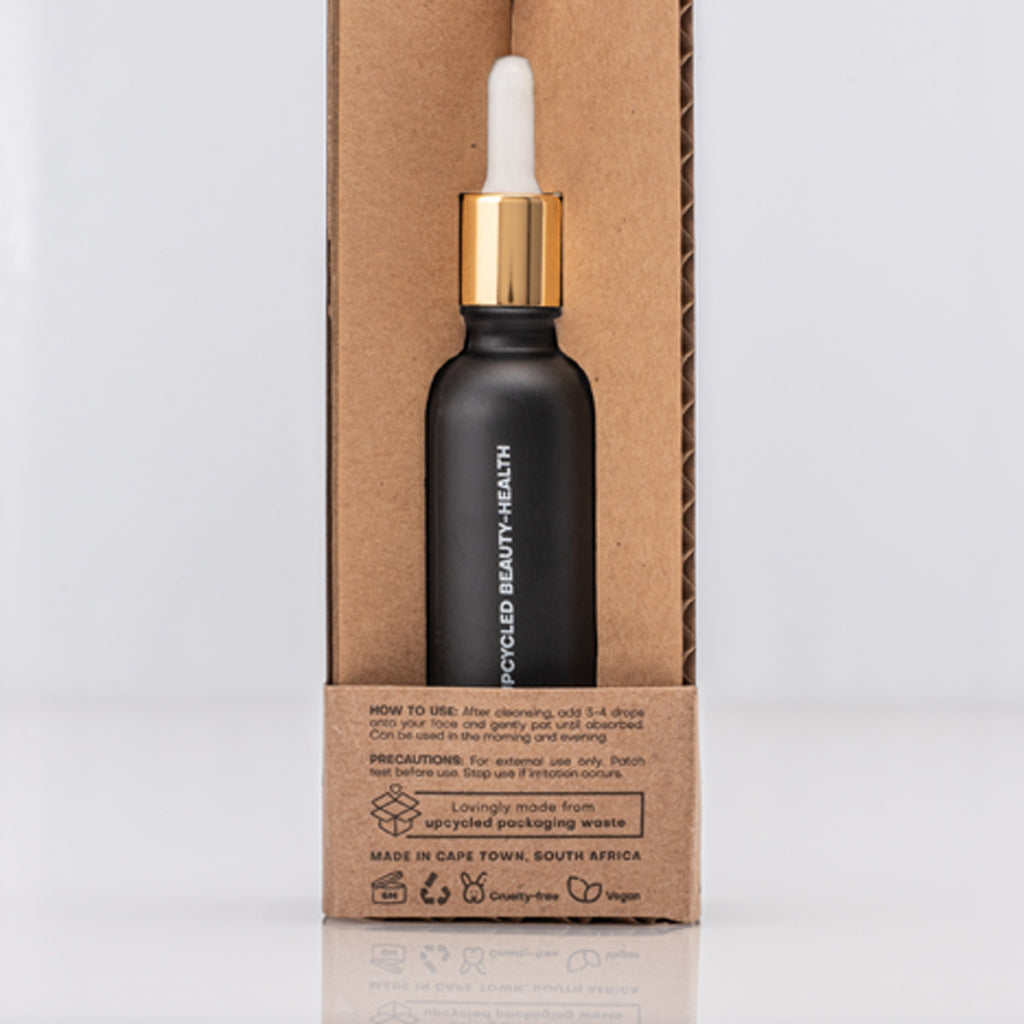 Black dropper bottle with gold cap containing Caffeine Antioxidant serum on a cardboard box with usage instructions in text