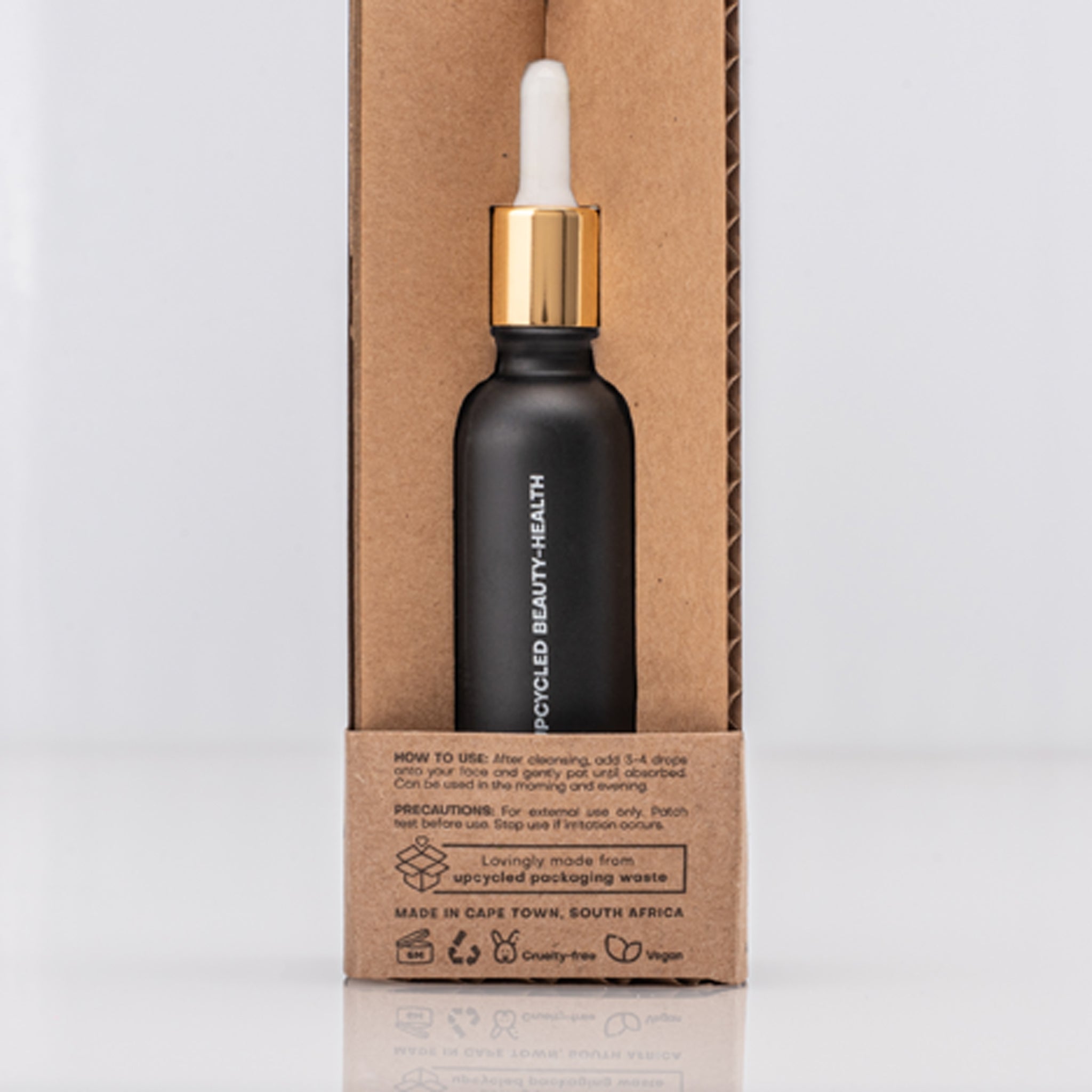 Black dropper bottle with gold cap containing Caffeine Antioxidant serum on a cardboard box with usage instructions in text