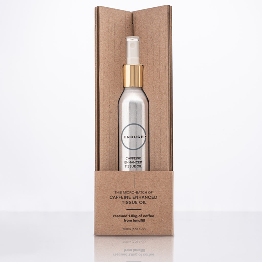 Spray bottle containing Caffeine Enhanced Tissues Oil in a cardboard packaging on a white background
