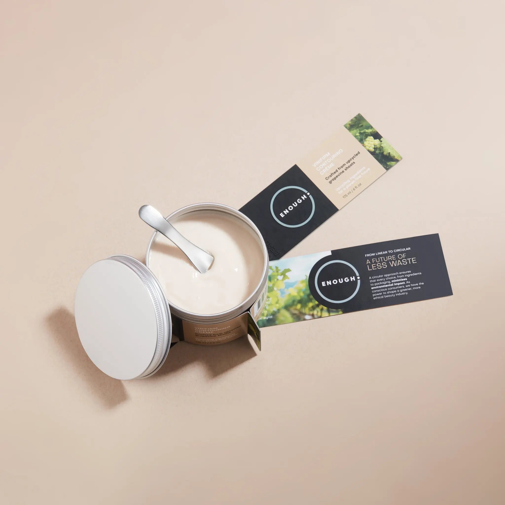 Cosmetic reusable container containing ENOUGH Vinifirm Contouring Crème opened with visible cream and spatula