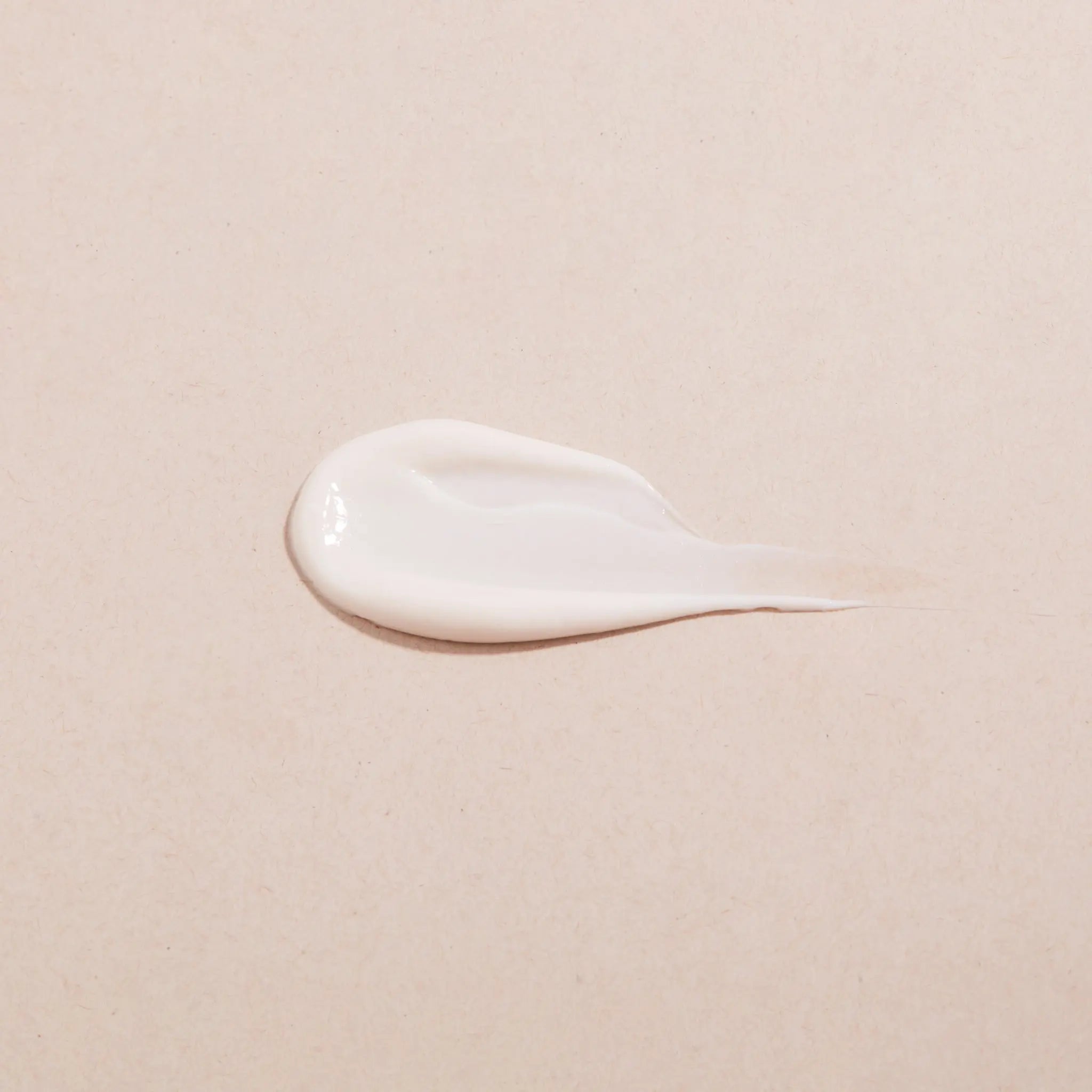 White cream smear on a beige background showing consistency of ENOUGH Vinifirm Countouring Crème