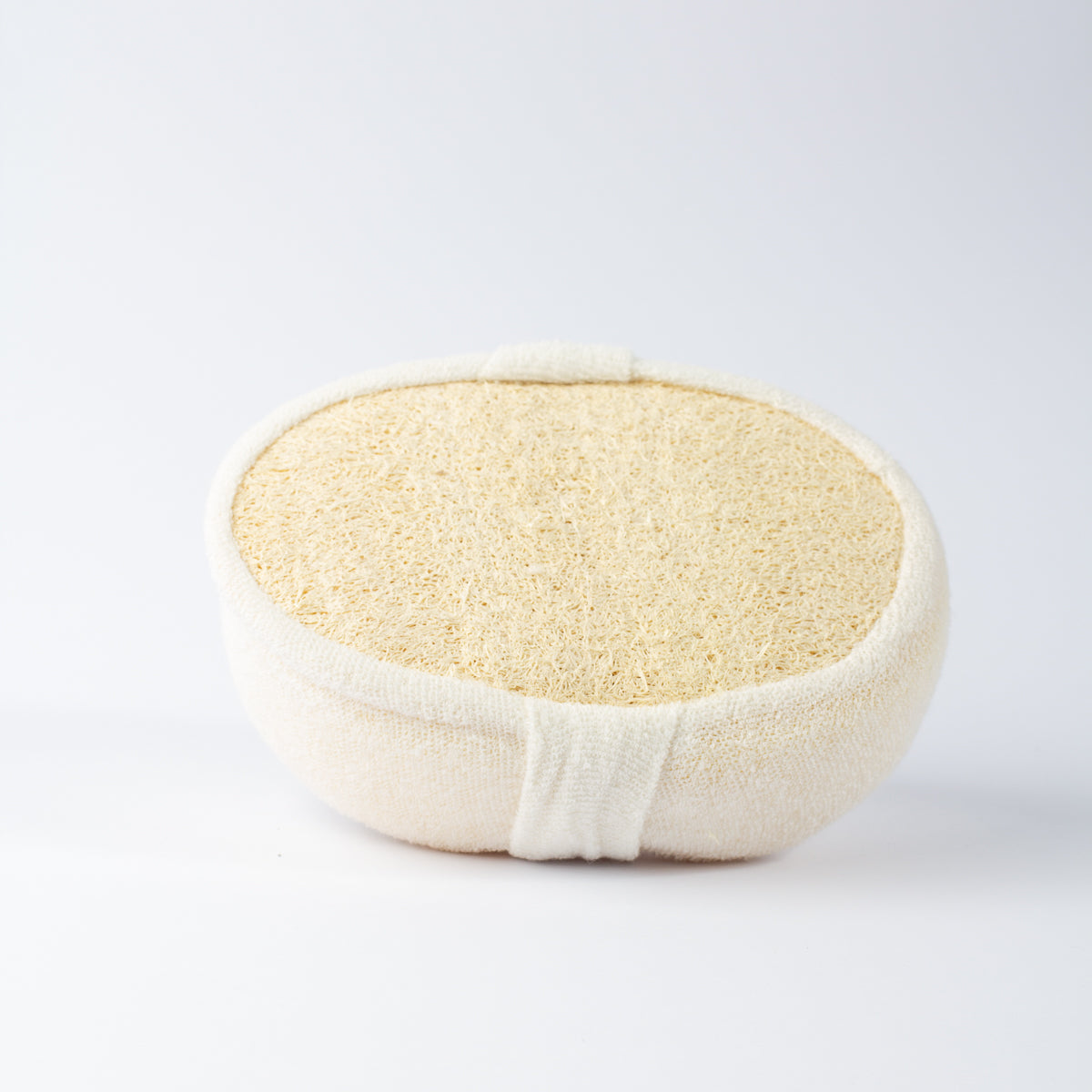 Side-angle view of ECONIQUE Natural Loofah Body Sponge with loofah face uppermost, cream and off-white tones against a clean white background