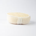 Profile view of ECONIQUE Natural Exfoliating Loofah Body Sponge revealing dual-layer construction — natural loofah top face and soft fabric underside — on white background