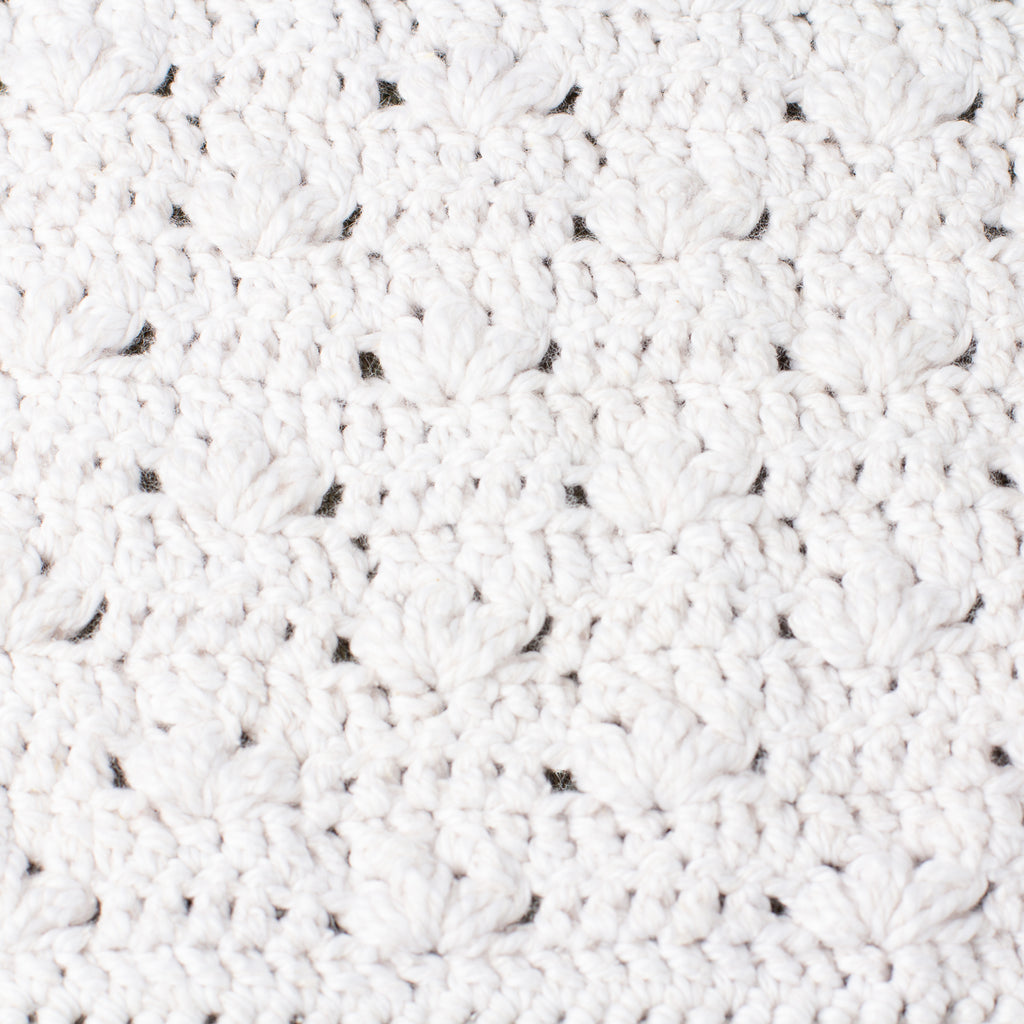 Close-up macro texture of ECONIQUE Papyrus natural cotton silk washcloth revealing open bamboo-stitch crochet weave in white