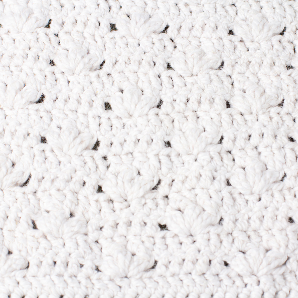 Close-up macro texture of ECONIQUE Papyrus natural cotton silk washcloth revealing open bamboo-stitch crochet weave in white