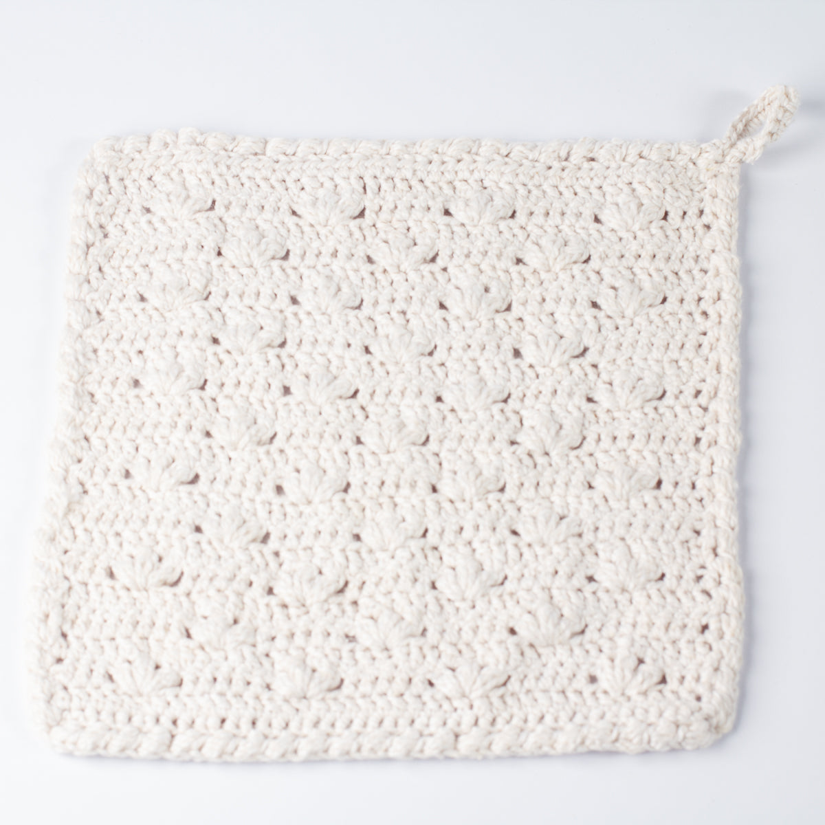 ECONIQUE Papyrus all natural cotton and silk washcloth in off-white, flat lay on white background showing crochet bamboo-stitch pattern and hanging loop